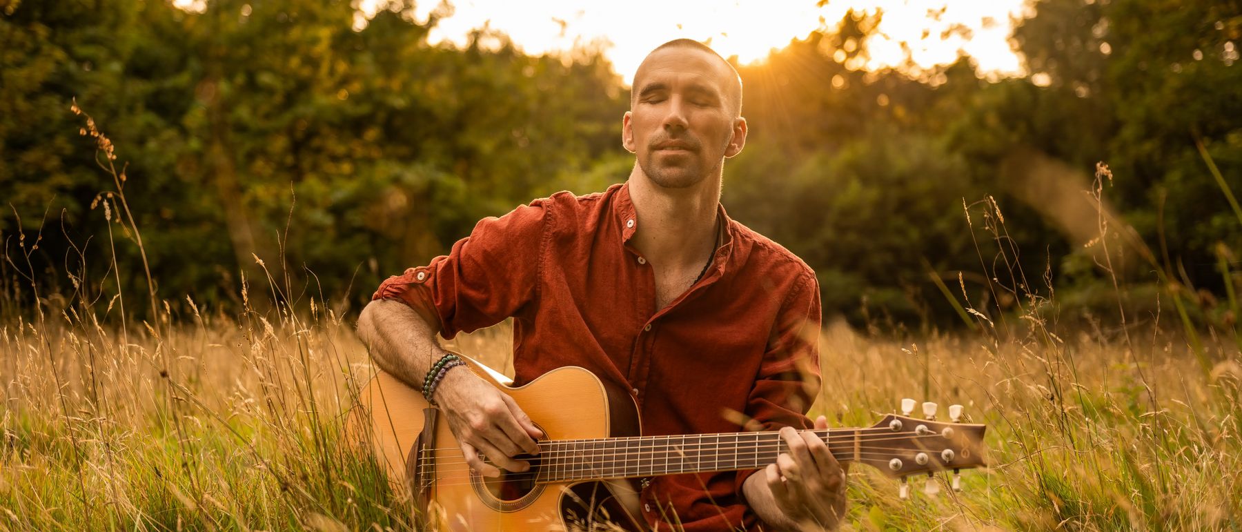 Jorn Ayan playing guitar at sunset