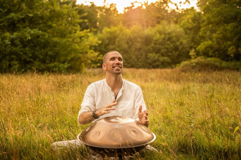 Jorn Ayan playing handpan in a meadow