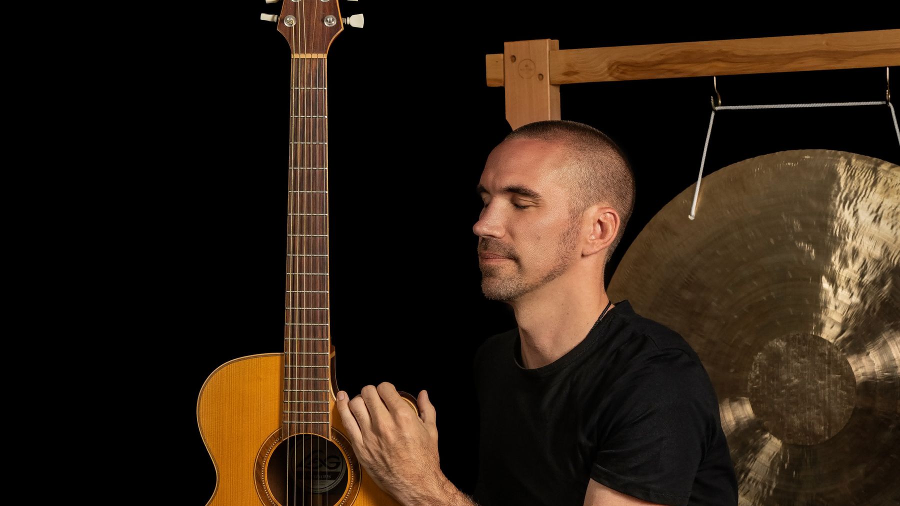 Close-up of Jorn Ayan with an acoustic guitar