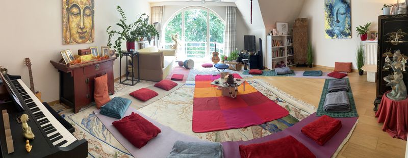 A living room set for a circle, cushions in a ring around a low table
